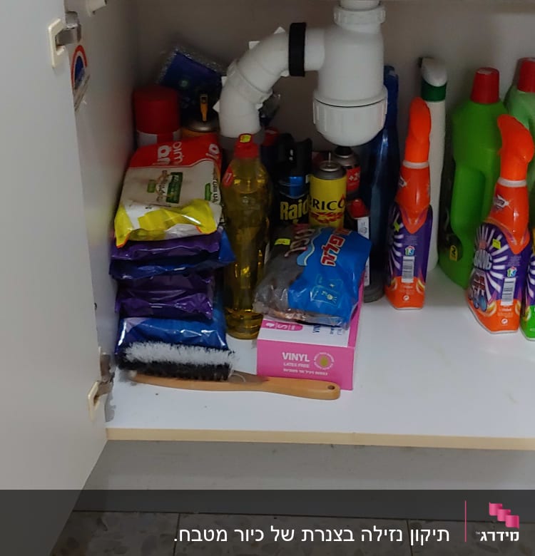 צינור ניקוז לבן מתחת לכיור במטבח